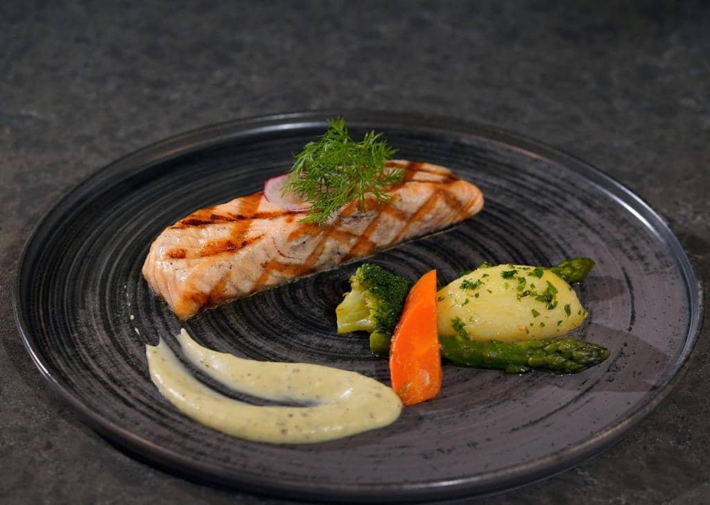 Mövenpick Hotel Istanbul Asia Airport - a black plate of food with fish and vegetables at Mövenpick Hotel Istanbul Asia Airport in Istanbul