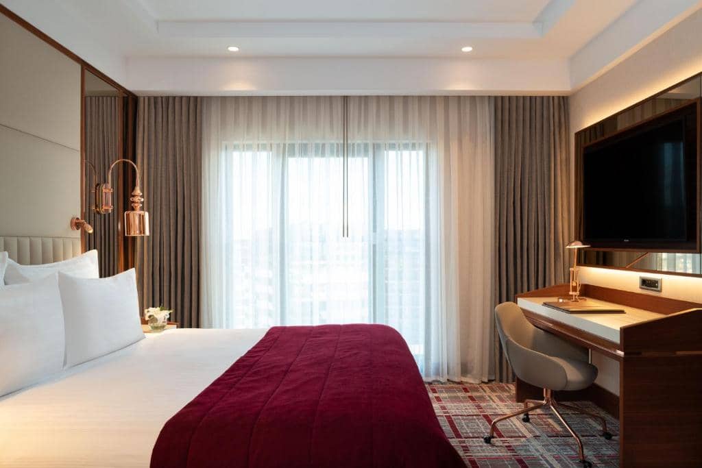 Mövenpick Hotel Istanbul Asia Airport - a hotel room with a bed and a desk and a television at Mövenpick Hotel Istanbul Asia Airport in Istanbul