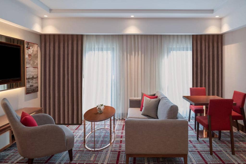 Mövenpick Hotel Istanbul Asia Airport - a hotel room with a couch and chairs and a table at Mövenpick Hotel Istanbul Asia Airport in Istanbul