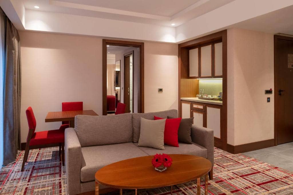 Mövenpick Hotel Istanbul Asia Airport - a living room with a couch and a table at Mövenpick Hotel Istanbul Asia Airport in Istanbul