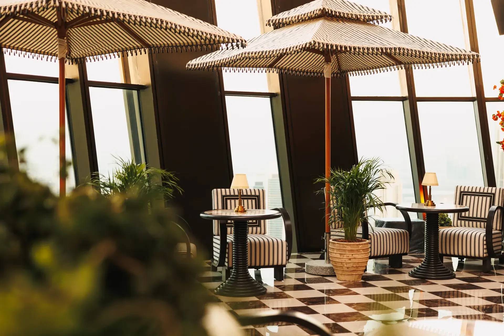 Lion in the Sun Dubai elegant interior with striped furniture and plants.