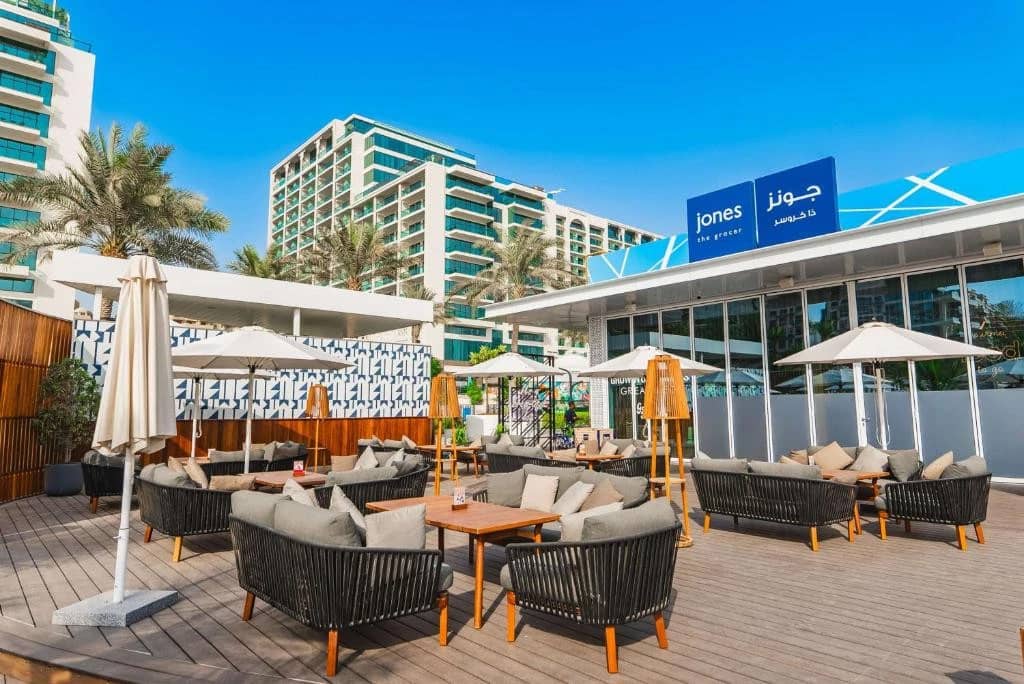 Outdoor seating at Hilton Dubai Palm Jumeirah with umbrellas and sofas.