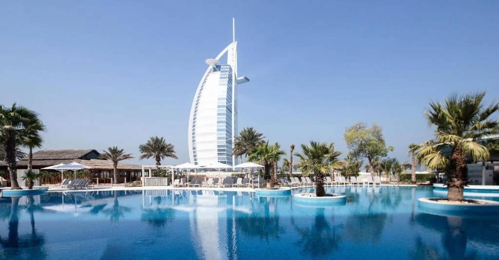 Jumeirah Beach Hotel pool with Burj Al Arab in background, Dubai.