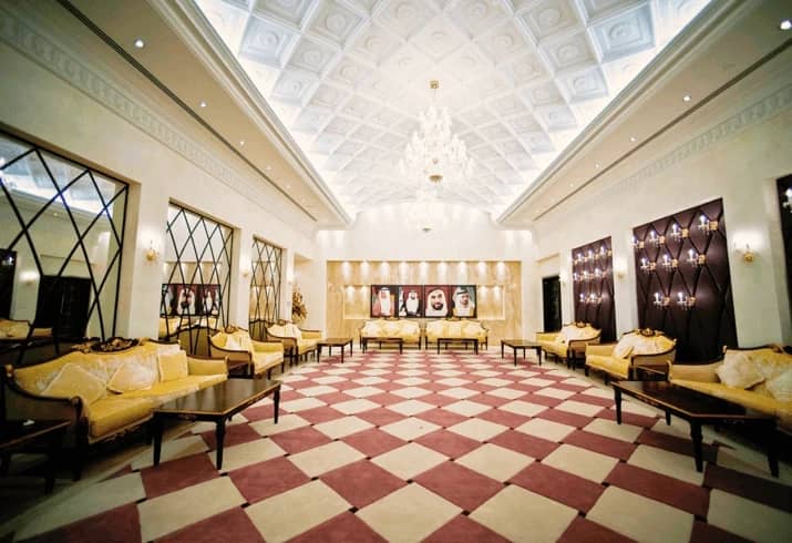 Elegant hall at Dubai World Trade Centre with chandeliers and portraits.