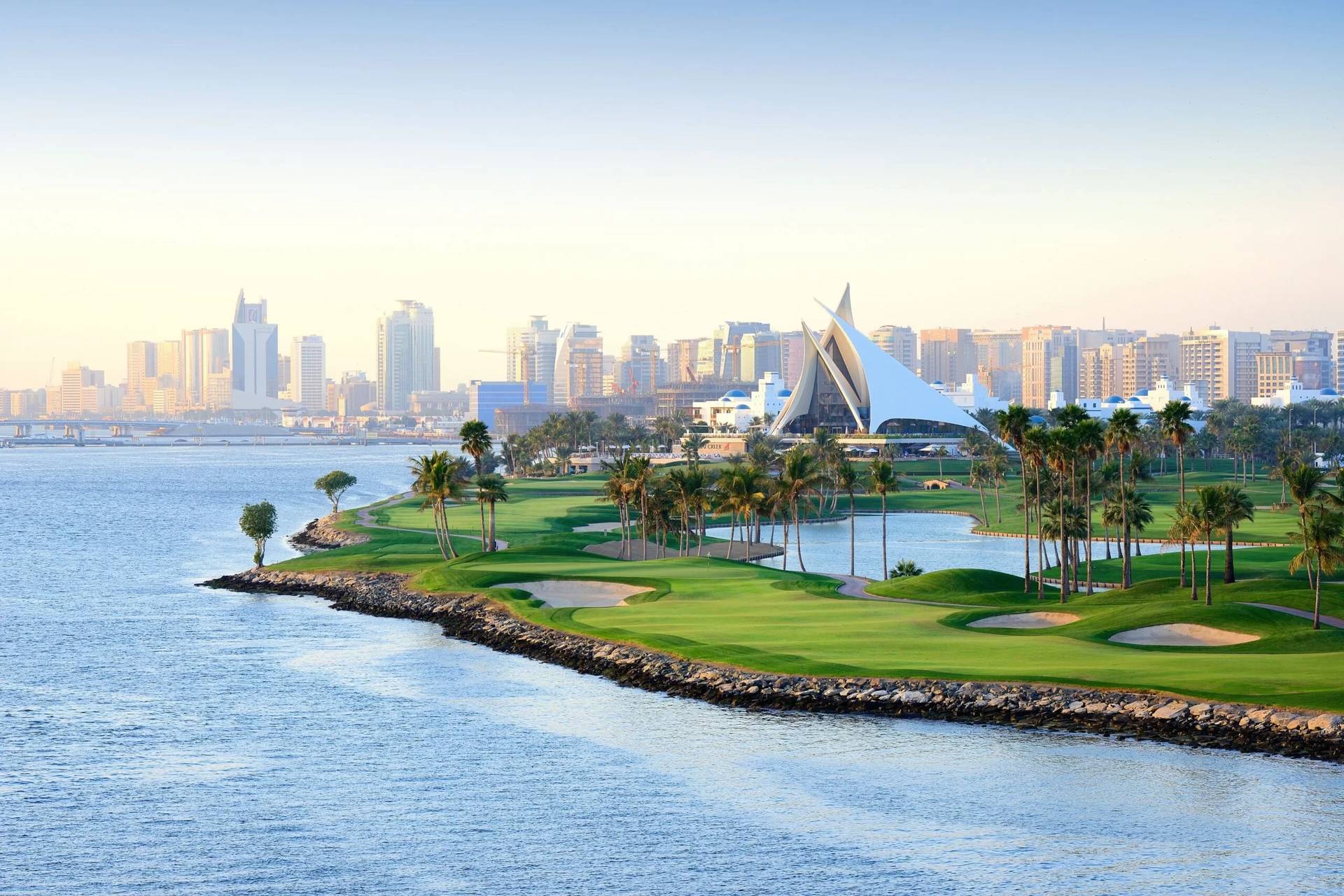Dubai Creek Golf & Yacht Club by waterfront, city skyline view.
