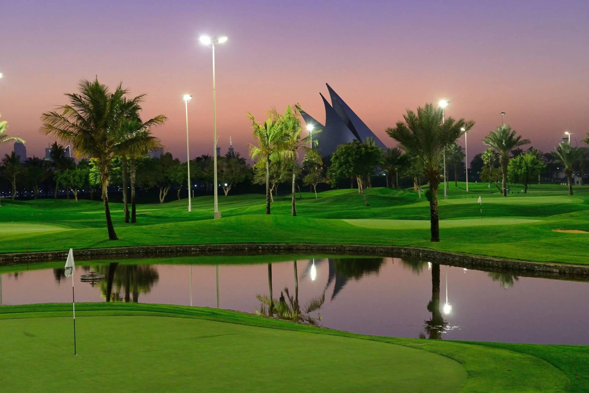 Dubai Creek Golf & Yacht Club at sunset, lush greens and water.