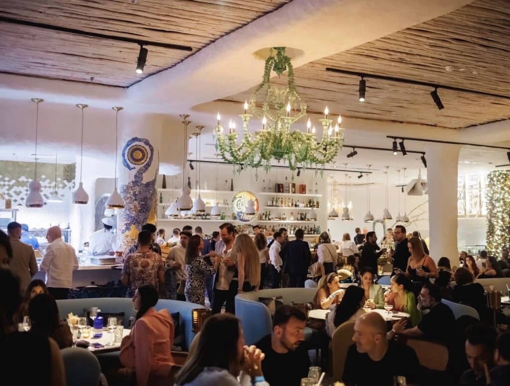 Gallery 7/40 Dubai, lively dining atmosphere with chandeliers and patrons.