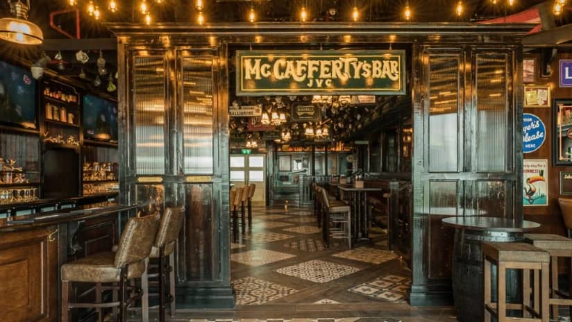 Interior of McCafferty's Pub Jumeirah Village, Dubai, with wooden decor.