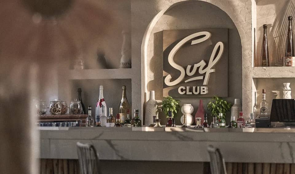 Surf Club Dubai bar with bottles and decorative elements.