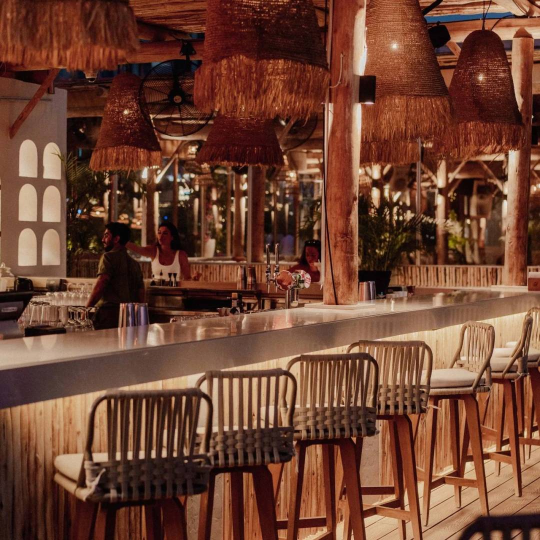 Cozy bar area at Surf Club Dubai with wicker chairs.