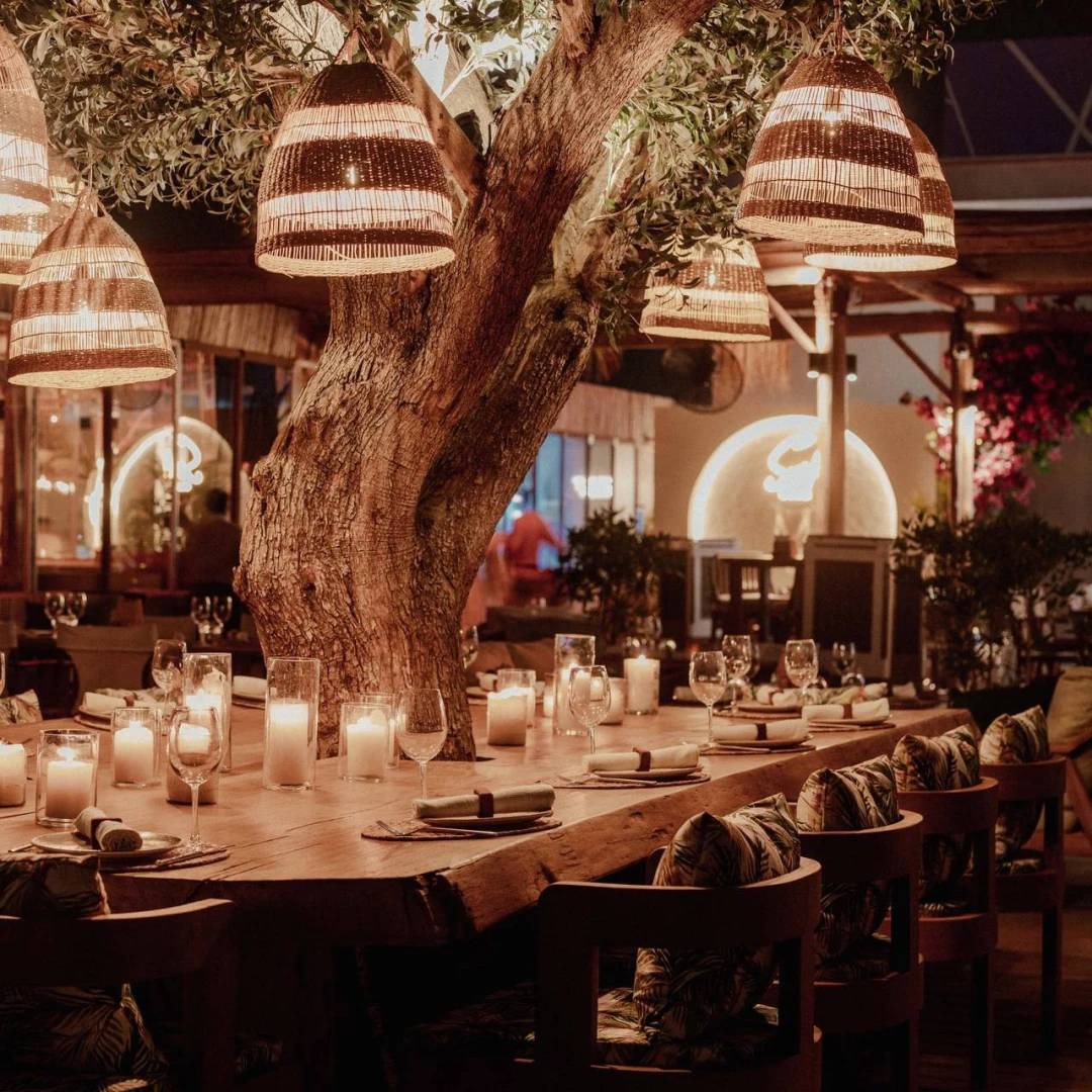 Candlelit dining table under tree at Surf Club Dubai.