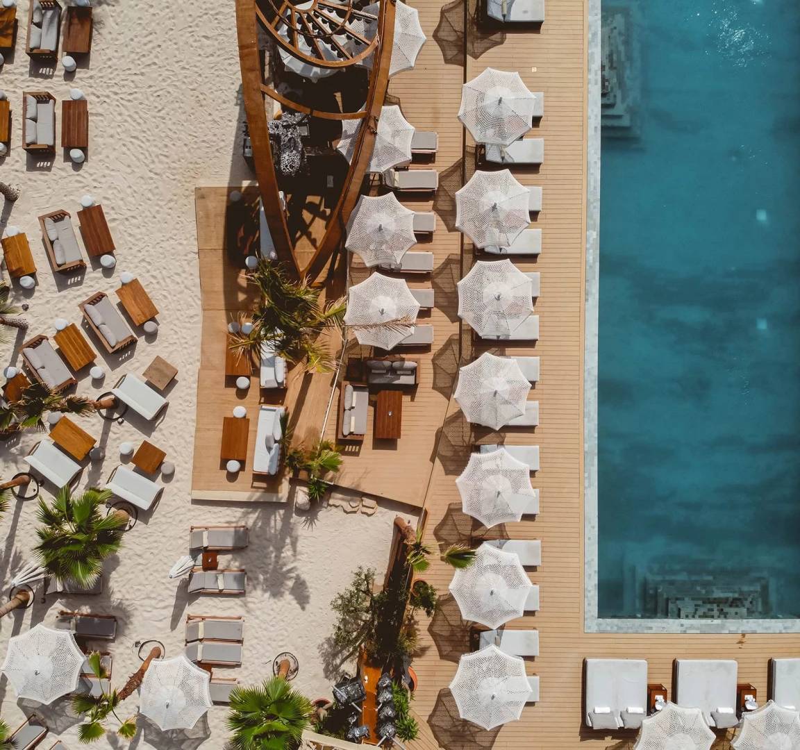 Aerial view of Be Beach DXB with pool and lounge chairs.