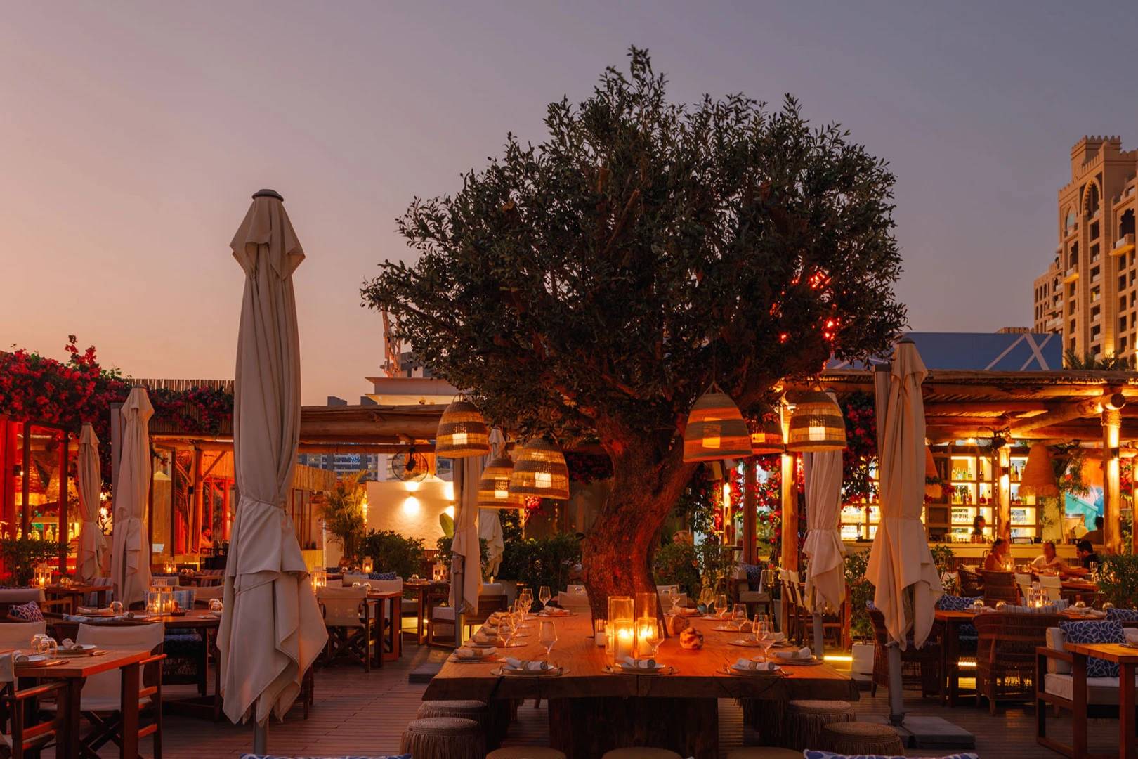 Outdoor dining area at Surf Club Dubai during sunset.