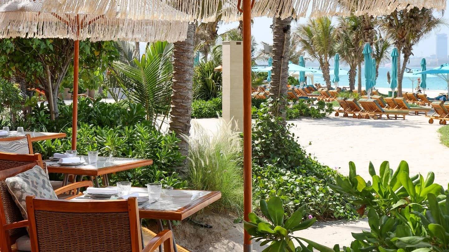 Outdoor dining at Surf Club Dubai with beach view.