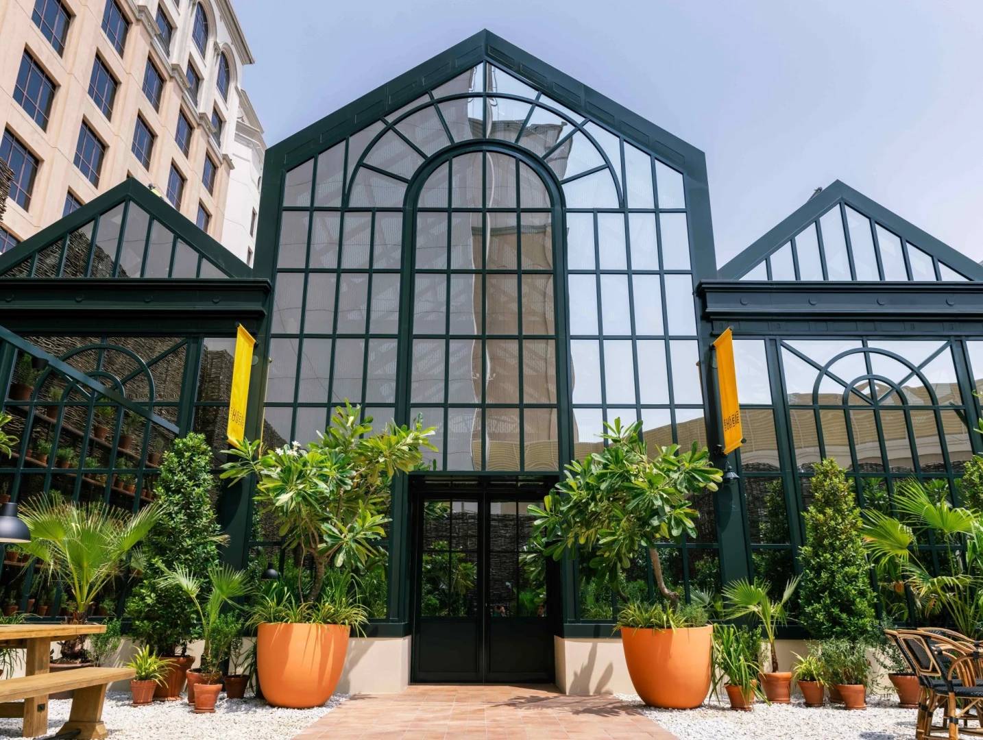 Eugène Eugène Restaurant Dubai entrance with glass facade and plants.