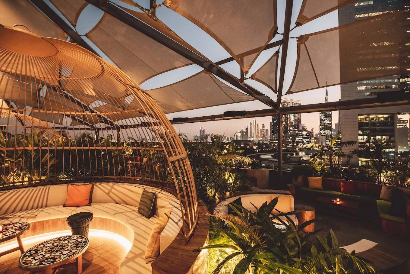 Stylish rooftop seating at Monkey Bar Dubai with city skyline view.