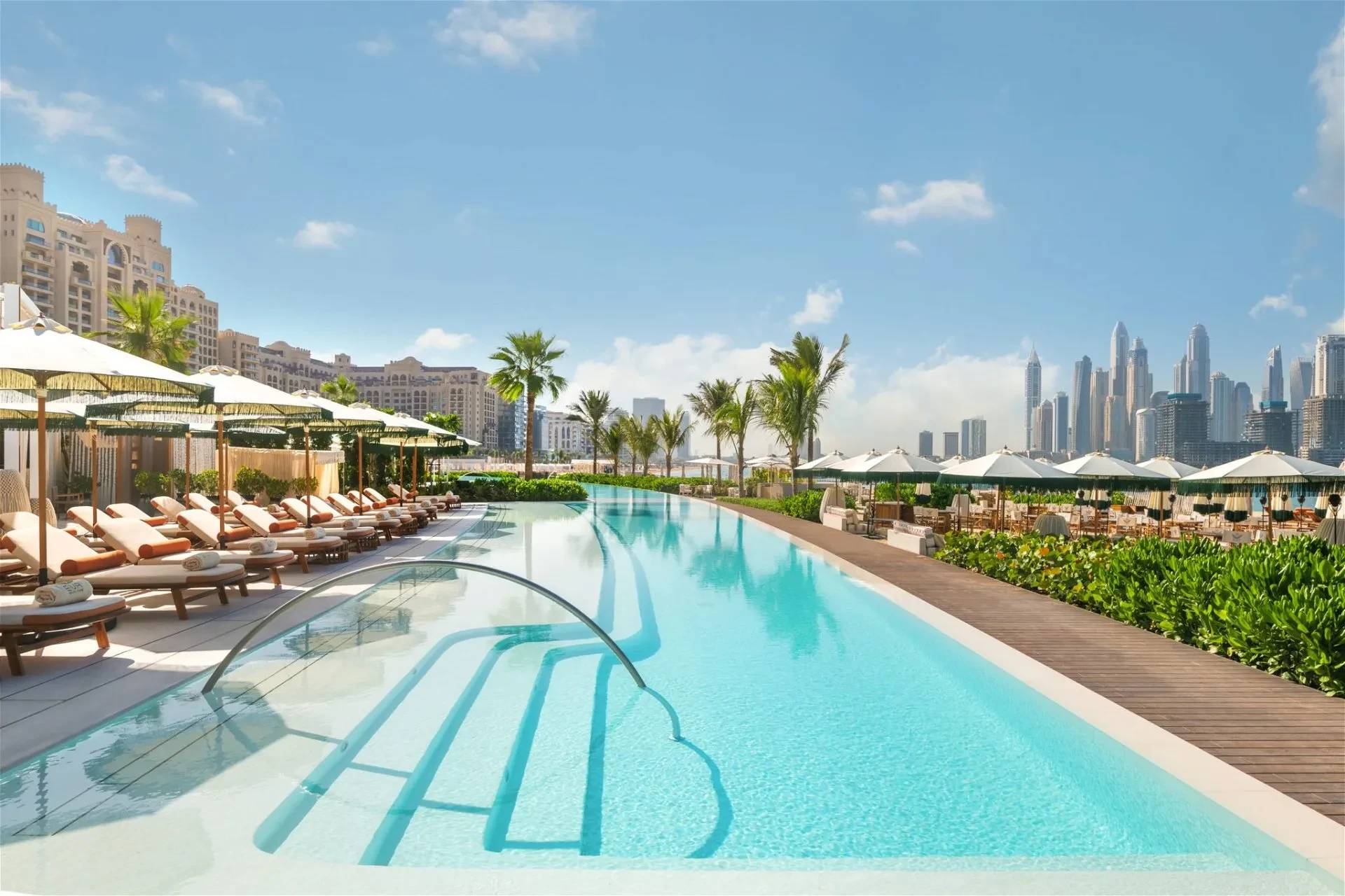 EVA Beach Restaurant poolside with Dubai skyline in background.