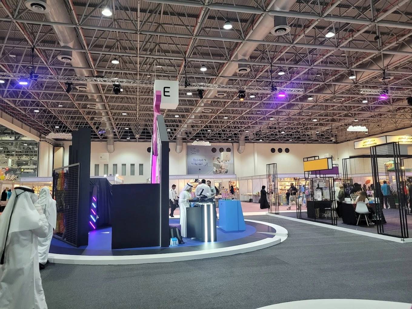 Expo Centre Sharjah interior with attendees and exhibition booths.