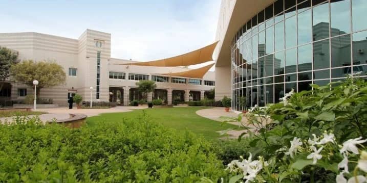 HCT Dubai Al-Nahda Campus Auditorium exterior with garden view.