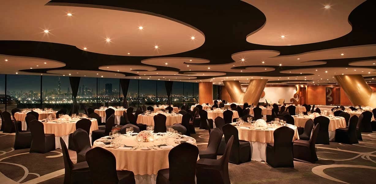 Elegant banquet hall at The Meydan Hotel, Dubai, with city view.