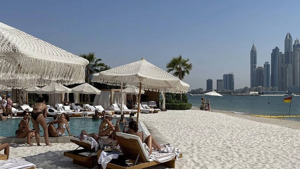 Kyma Beach Dubai with loungers, umbrellas, and city skyline view.