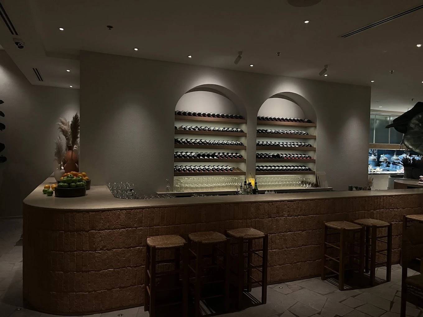 Elegant bar with wine shelves at Mythos Urban Greek Eatery, Dubai.