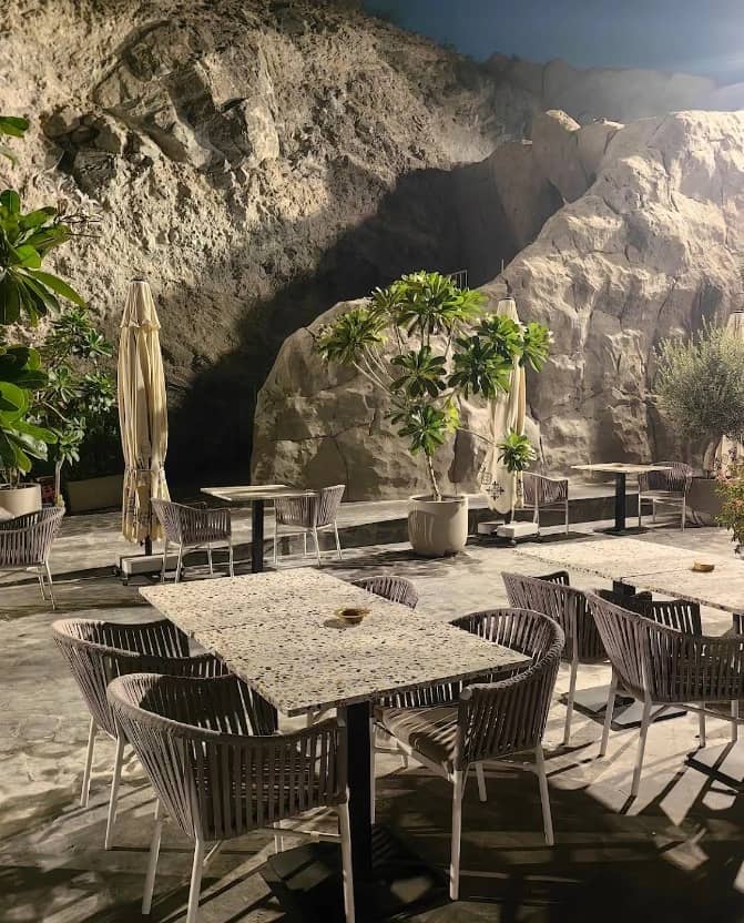 Outdoor seating at Habib Beirut Restaurant Khorfakkan, Sharjah, with rocky backdrop.