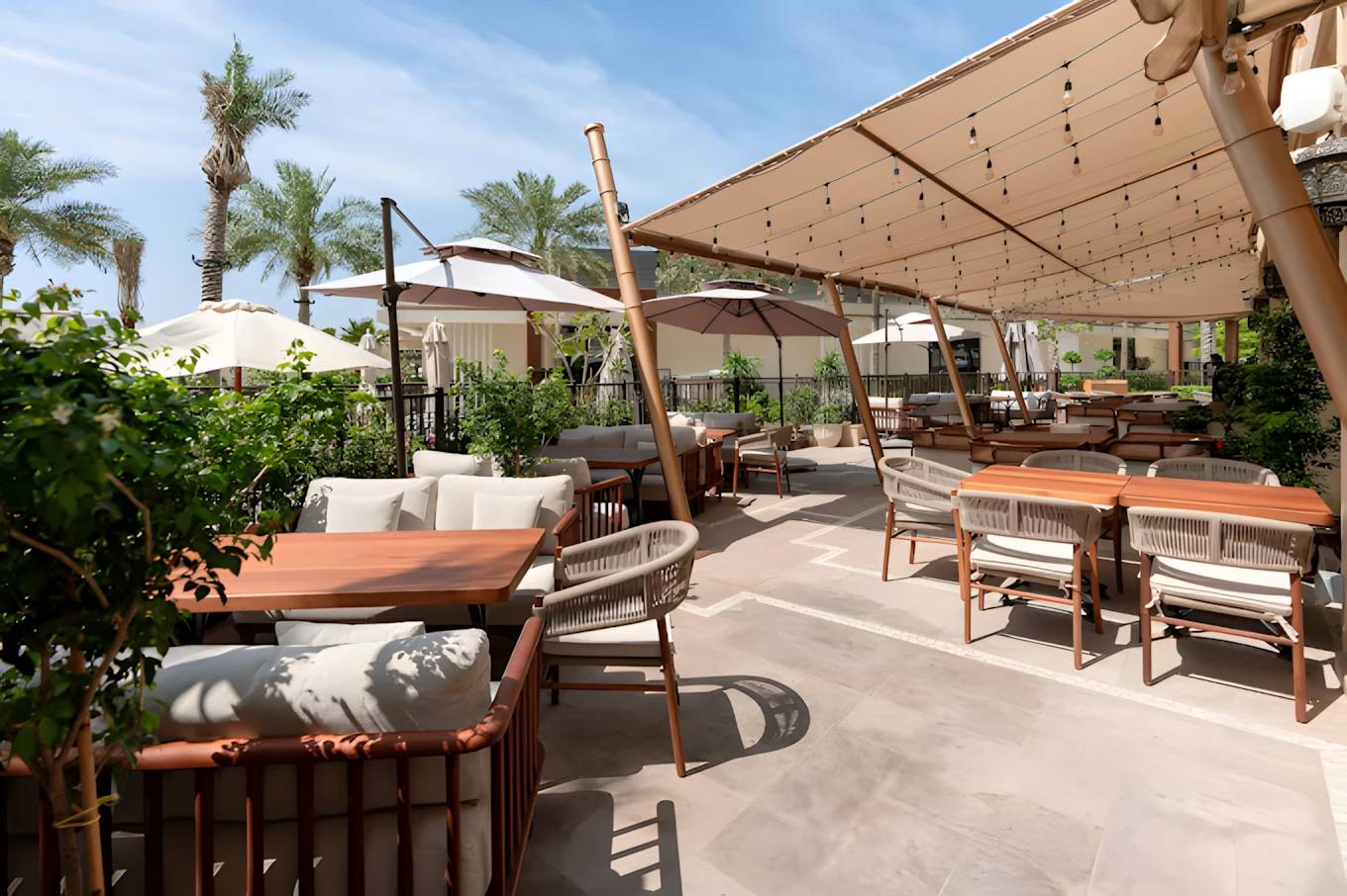 Outdoor seating at Grand Zor Restaurant Dubai with palm trees.