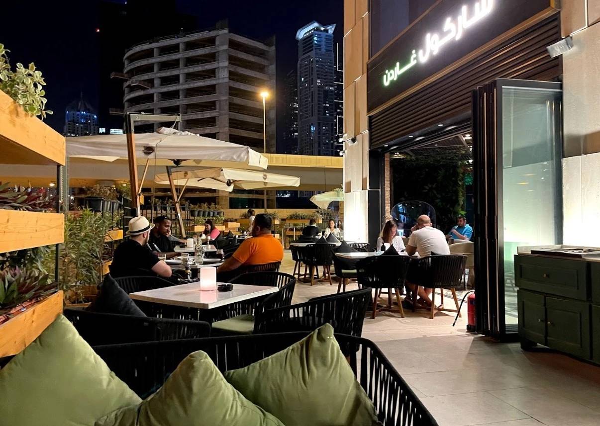 Outdoor dining at Charcoal Garden Restaurant, Dubai Media City, nighttime ambiance.