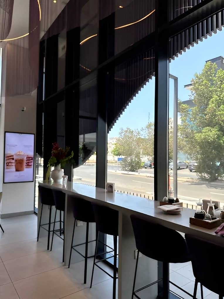 Modern interior of Myra Cafe Jeddah with street view.