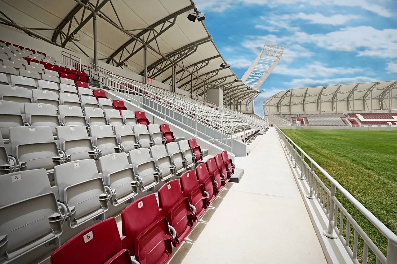 Abdullah Bin Khalifa Stadium seating, Doha, with clear sky.