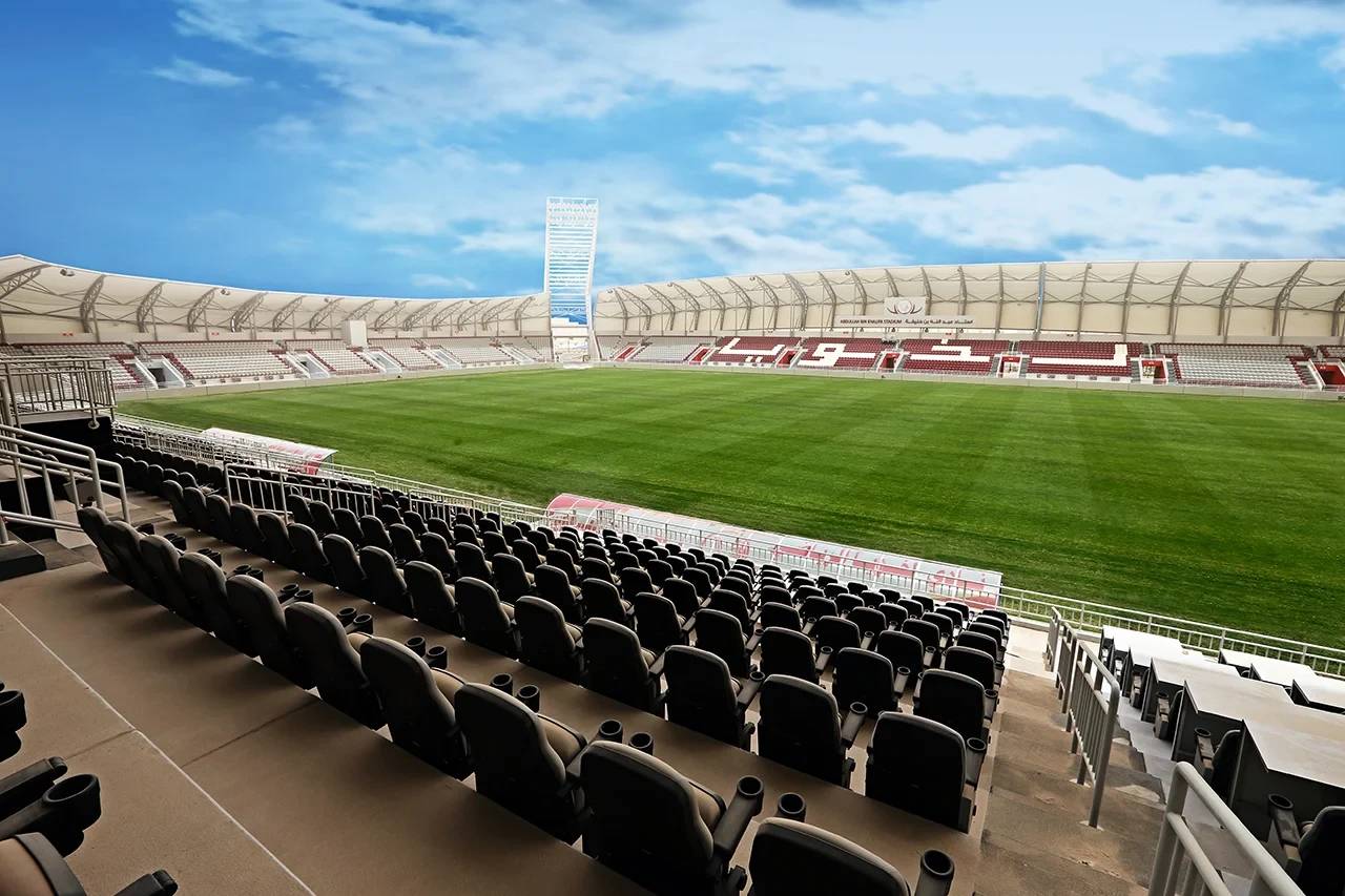 Abdullah Bin Khalifa Stadium in Doha, empty seats and green field.