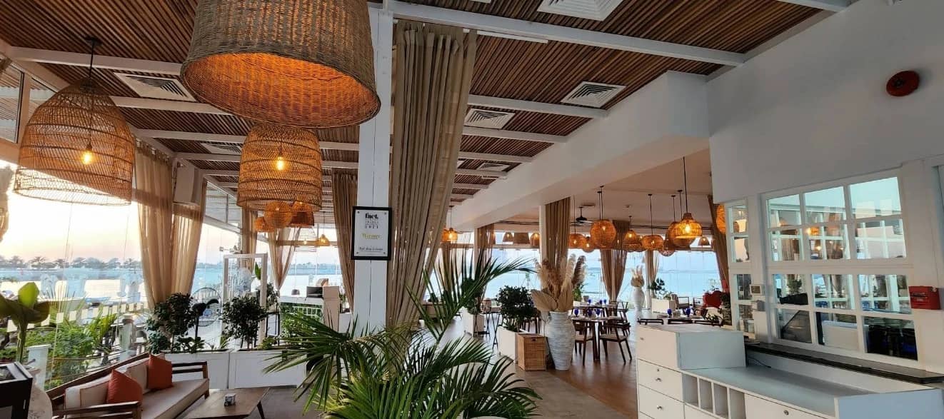 West Bay Lounge Abu Dhabi interior with wicker lights and plants.