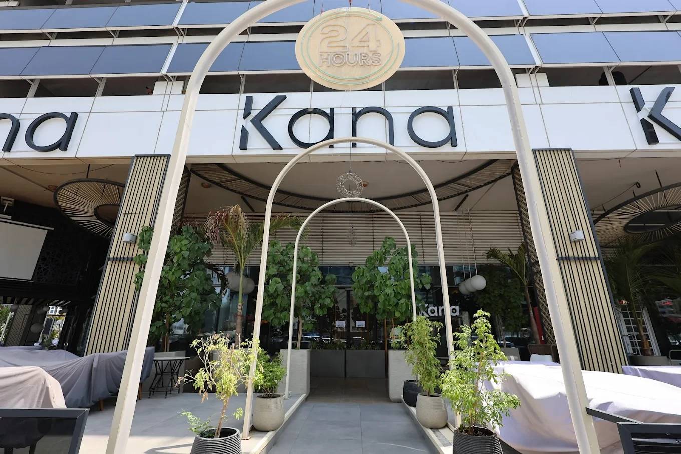 Entrance of The Kana Cafe Downtown Dubai with plants and arches.