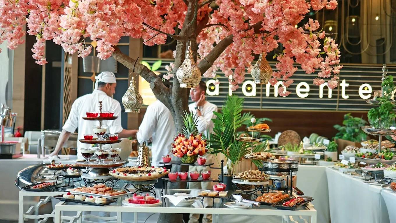 Buffet setup under cherry blossoms at The Kana Cafe Downtown Dubai.