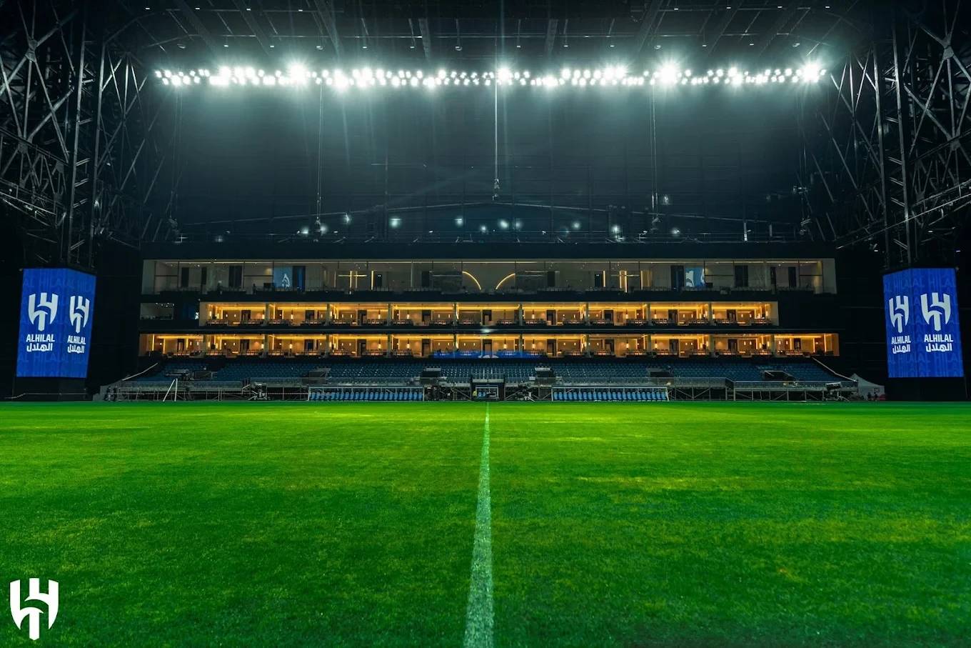 Kingdom Arena Riyadh illuminated field and seating area at night.