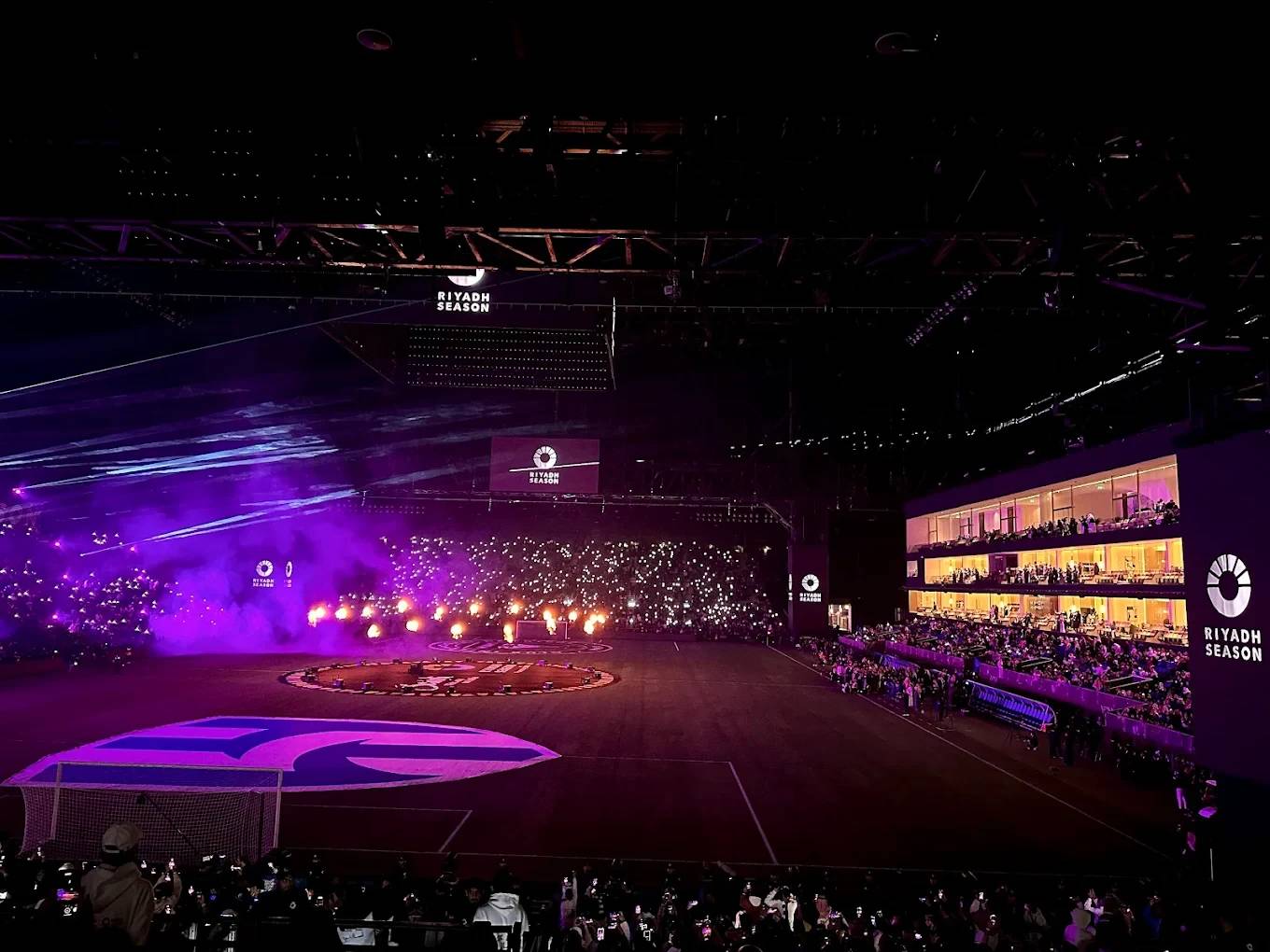 Kingdom Arena Riyadh illuminated during an event with vibrant lights.