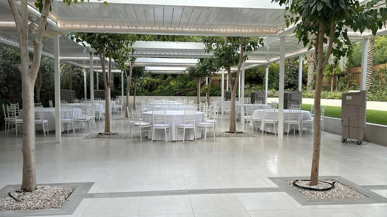 Covered patio with round tables, The Farm, Al Barari, Dubai.