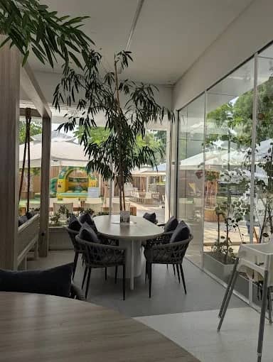 Dining area at The Farm Restaurant Al Barari, Dubai with greenery.
