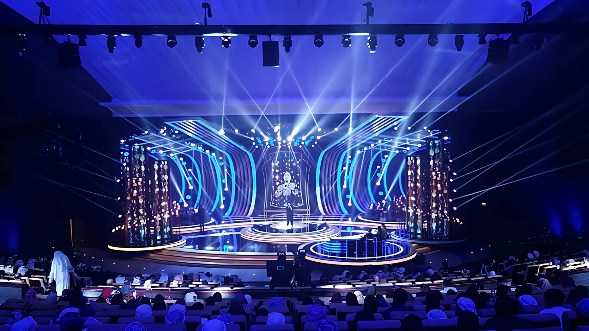National Theatre Abu Dhabi stage with vibrant blue lighting effects.