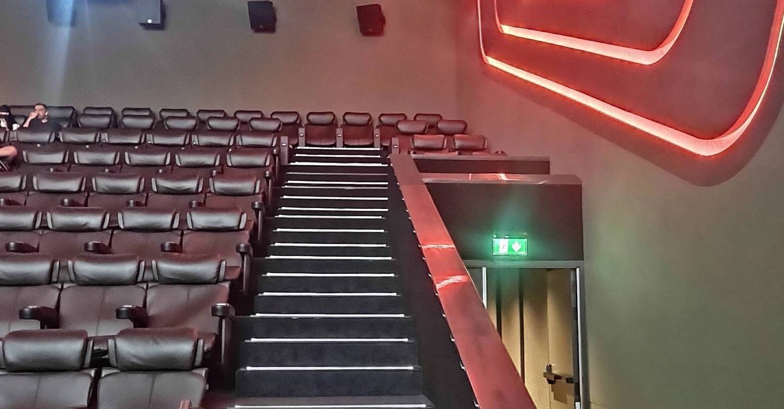 Empire Cinema Al Ahsa seating with illuminated exit sign, Al Hofuf.