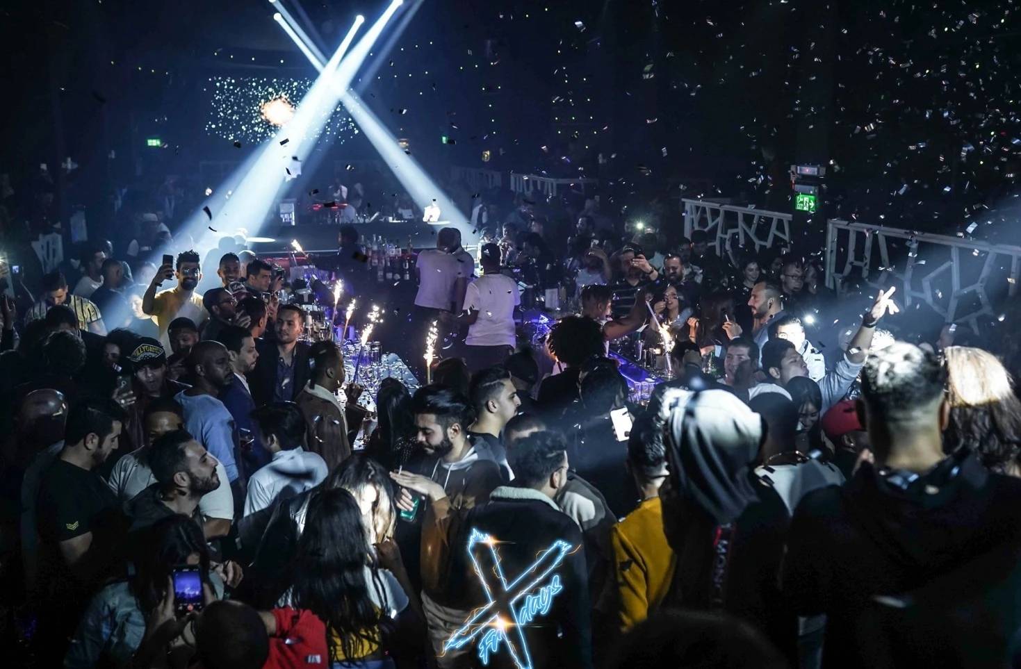 Crowded nightclub scene at OX Club Doha with lights and confetti.