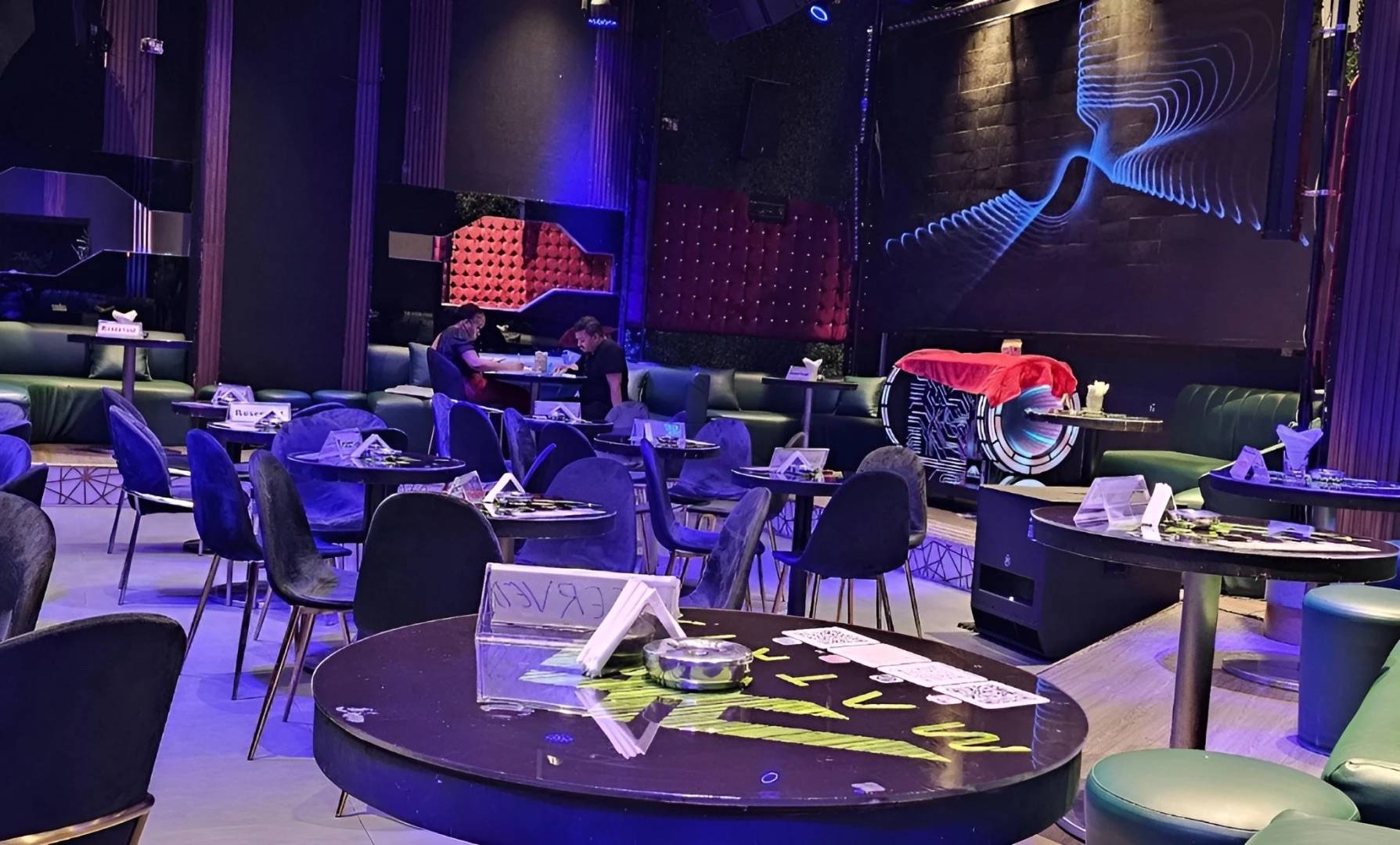 Matrix Club Qatar lounge area with tables and blue lighting, Doha.