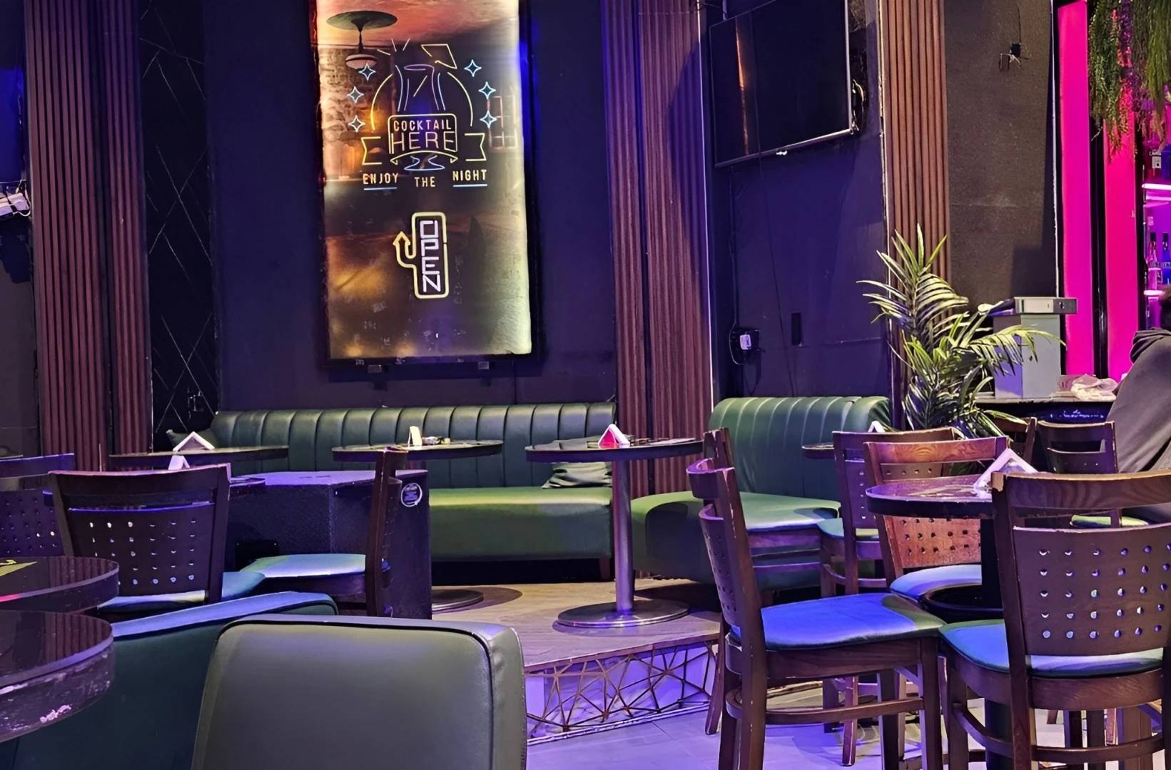 Matrix Club Qatar lounge area with tables and neon sign, Doha.