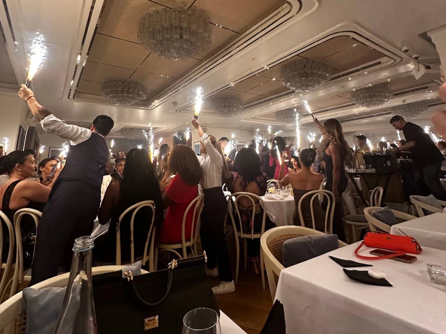 Guests celebrating with sparklers at Bagatelle Dubai venue.