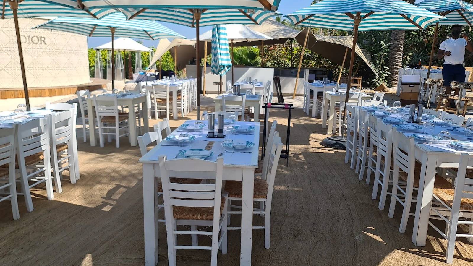 Outdoor dining setup at Nammos Dubai with striped umbrellas.