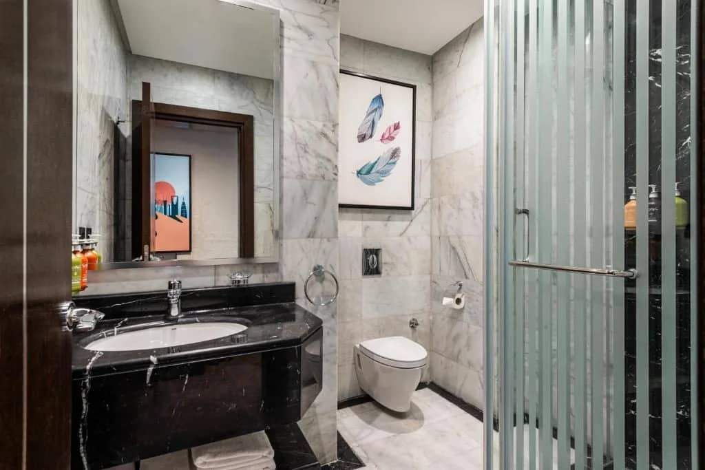 Modern bathroom with marble walls at Holiday Inn Riyadh al Malaz by IHG.