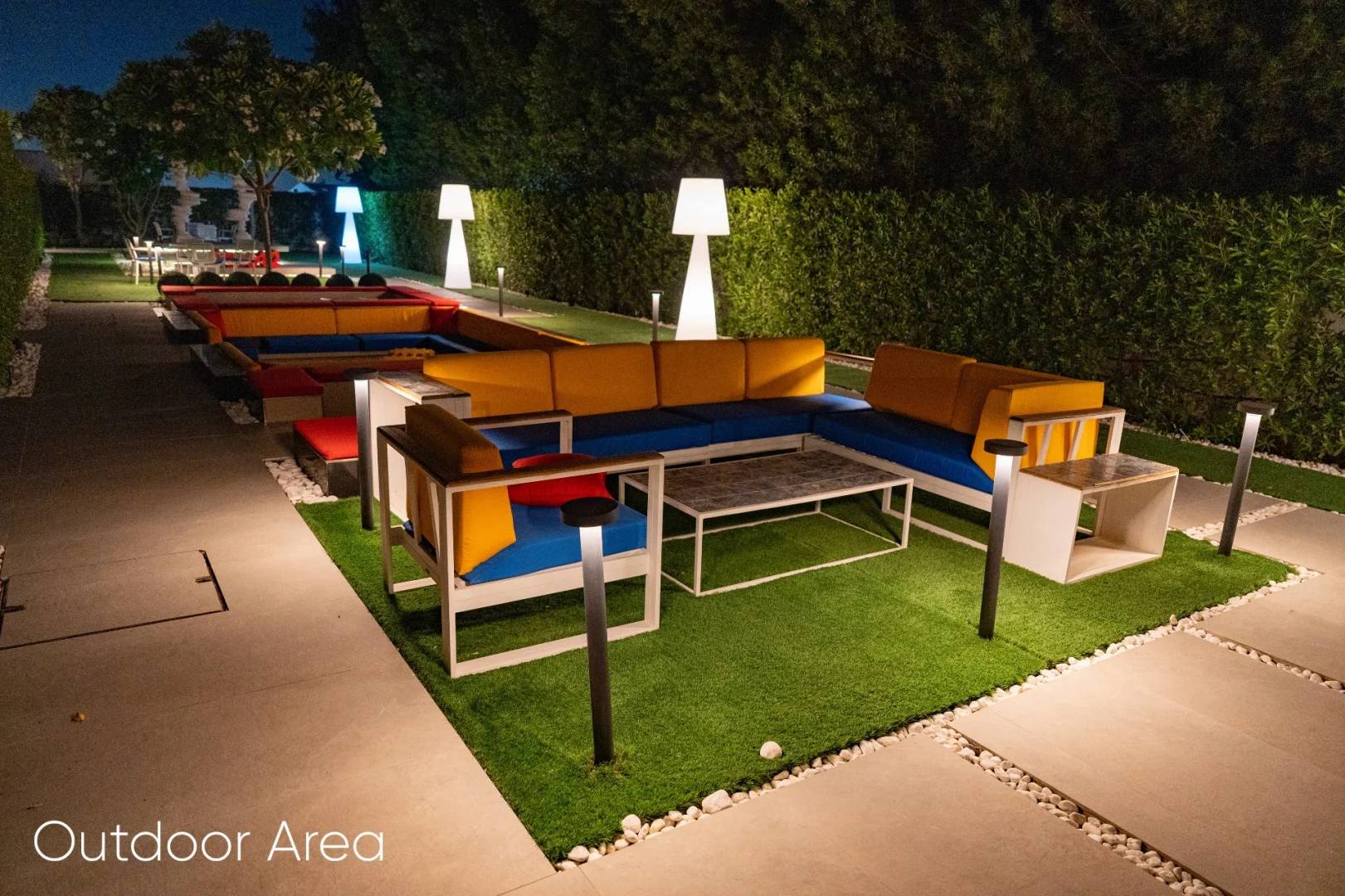 Outdoor seating area with colorful sofas at Aureum Club, Dubai, UAE.