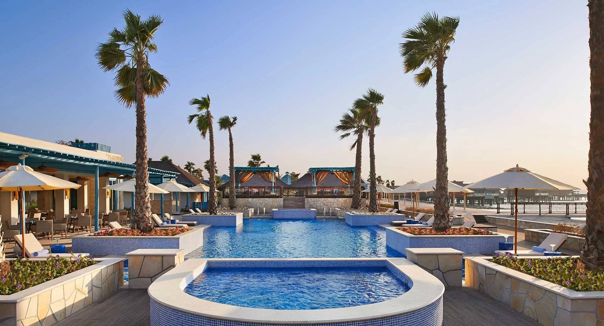 Outdoor pool area with palm trees at Banana Island Resort Doha By Anantara, Qatar