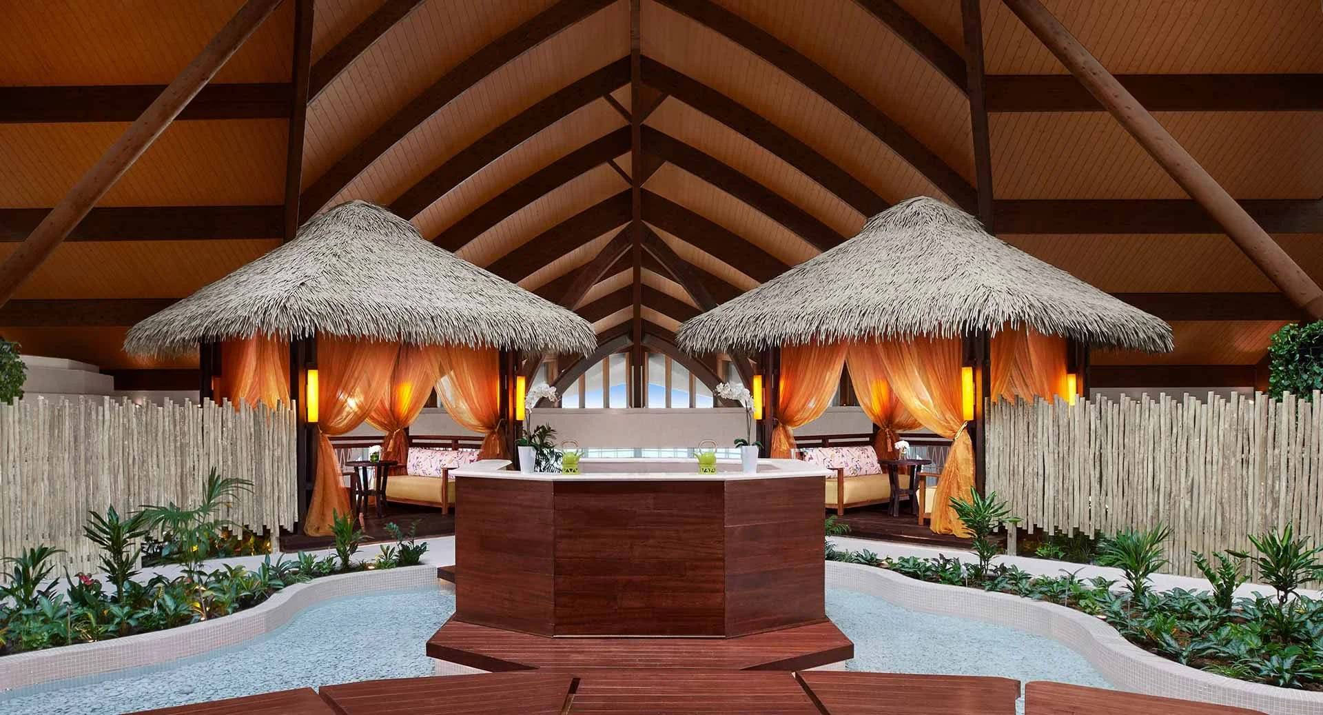 Thatched-roof cabanas and water feature at Banana Island Resort Doha By Anantara, Doha.